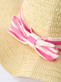Straw hat with a pink and white striped ribbon on a light background