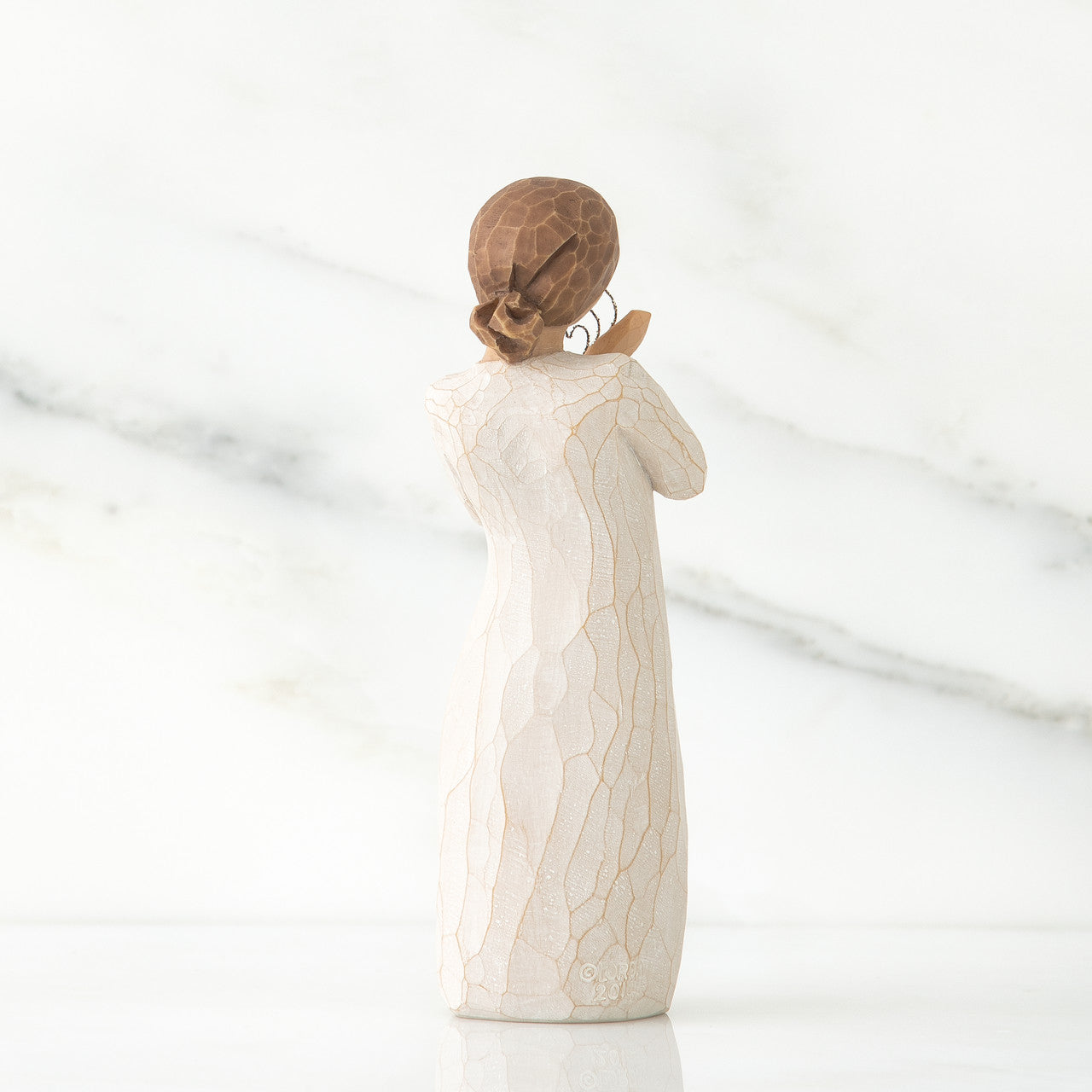 White ceramic figurine with textured surface on a white background