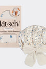 Satin bonnet with floral pattern next to its packaging on a white background