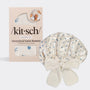 Satin bonnet with floral pattern next to its packaging on a white background