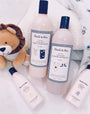 Noodle & Boo baby care products on a white surface with a plush lion toy.