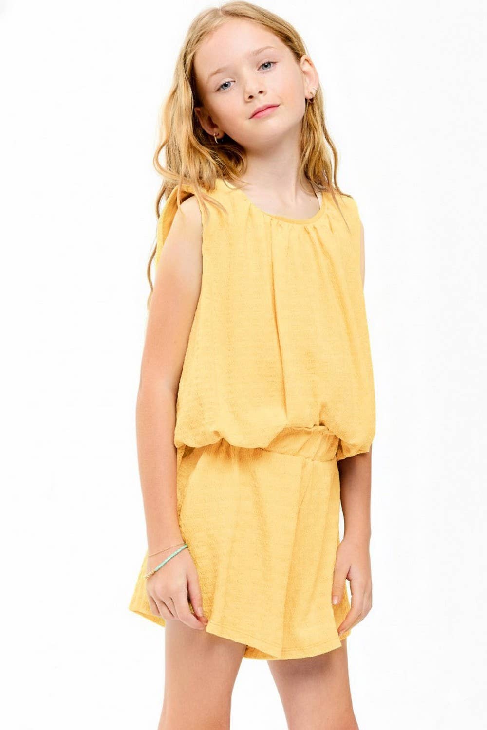 Young girl wearing a yellow set on a white background