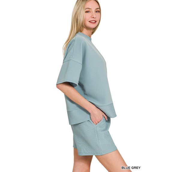 Woman wearing a blue-grey outfit on a white background