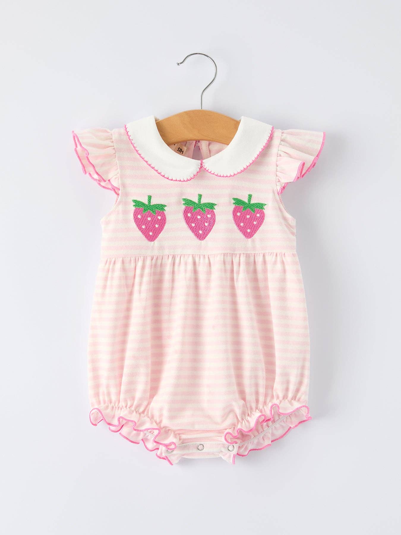 Pink baby romper with strawberry design on a white background