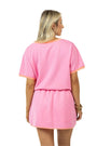 Woman wearing a pink outfit with a plain white background