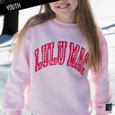 Child wearing a pink 'LULU MAC' sweatshirt with a checkered design outdoors.