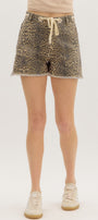 Person wearing leopard print shorts on a plain background
