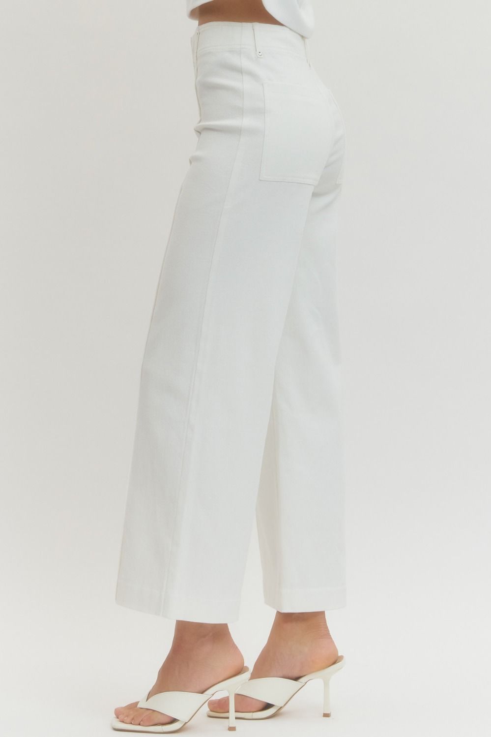 White pants worn by a person on a white background