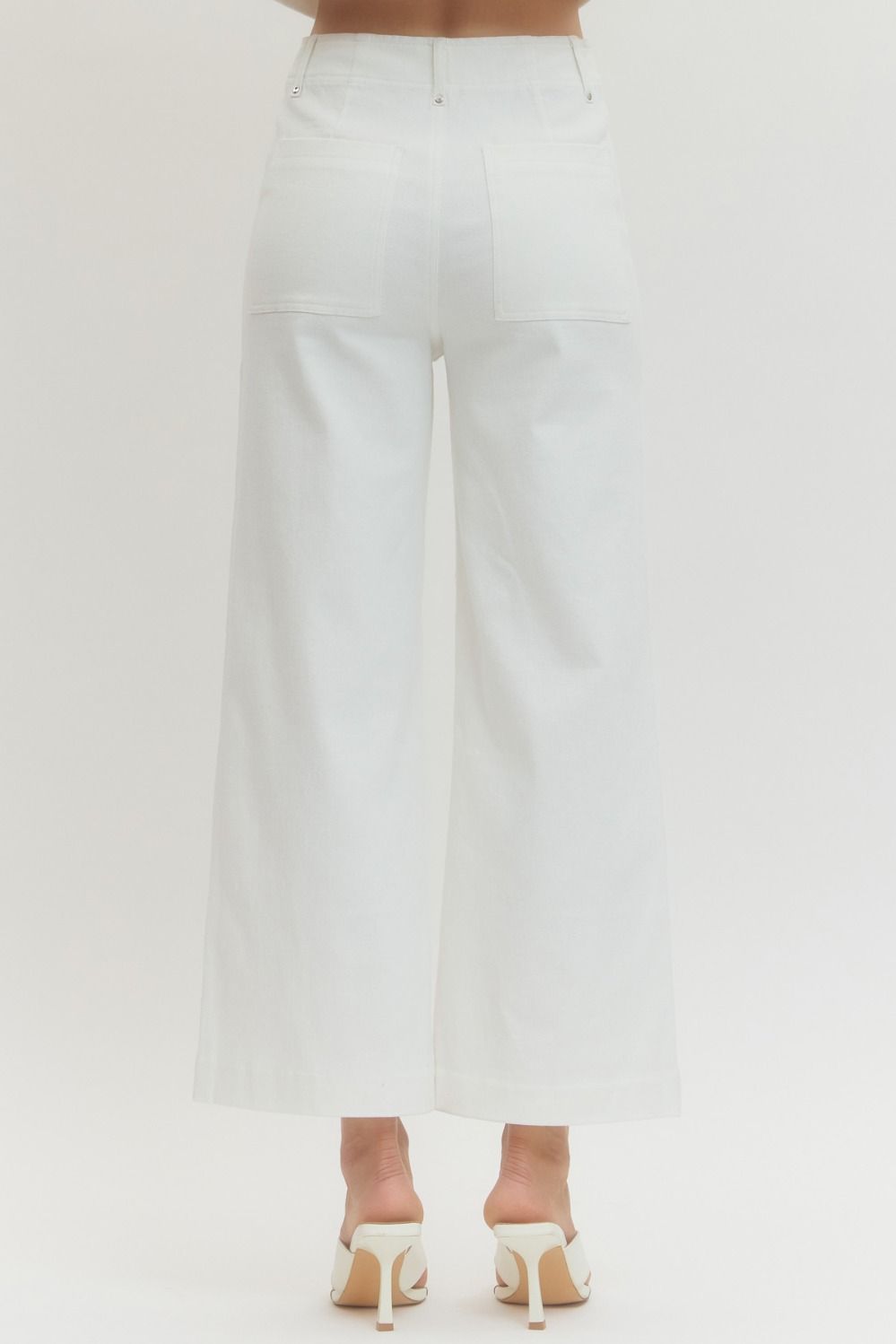 White pants worn by a person on a light gray background