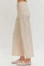 Beige pinstripe pants worn by a person on a white background