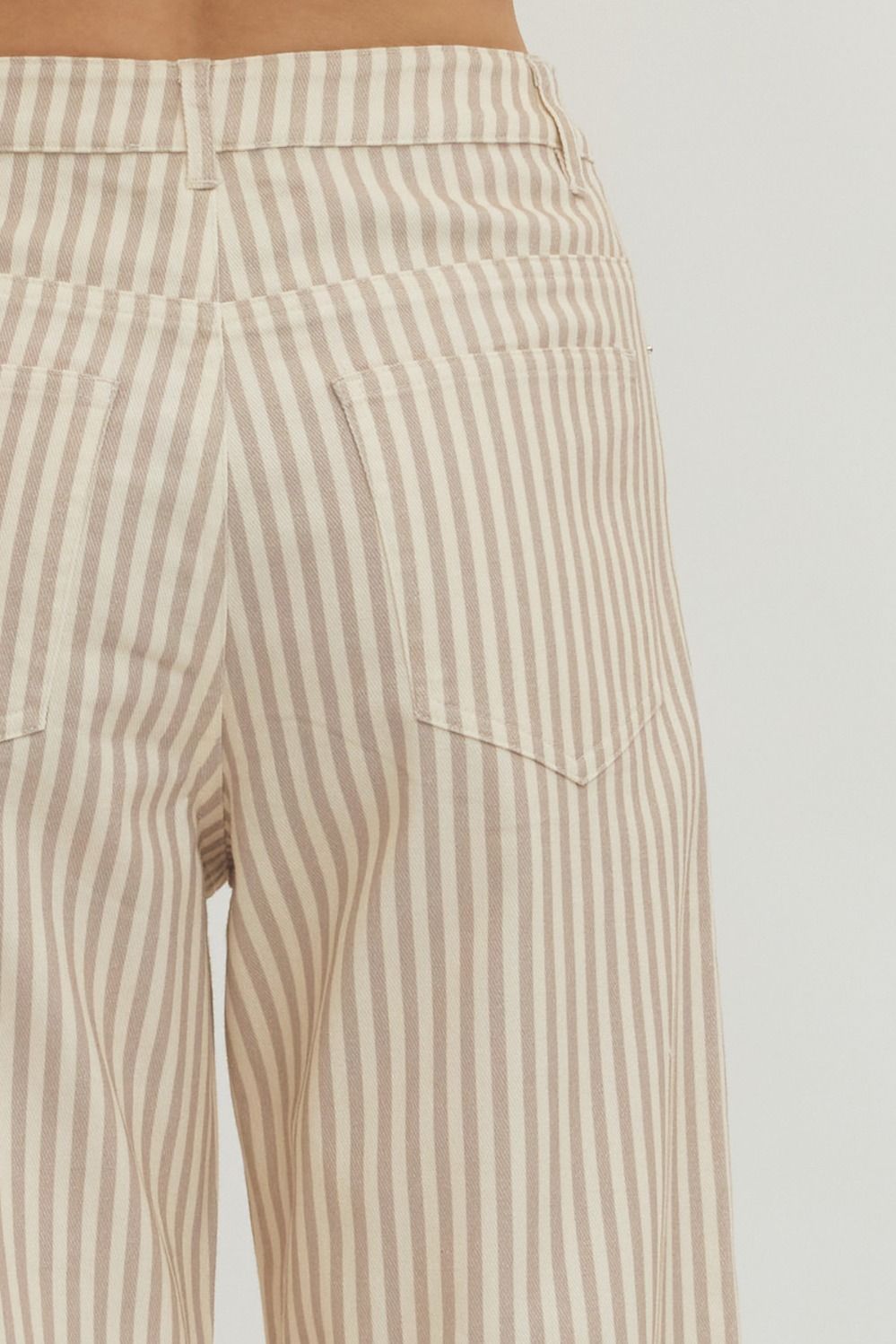 Beige and white striped pants on a plain background