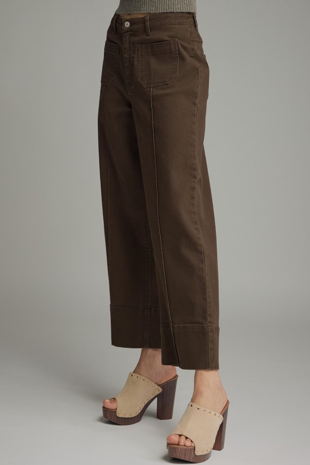 Brown pants worn by a person on a gray background