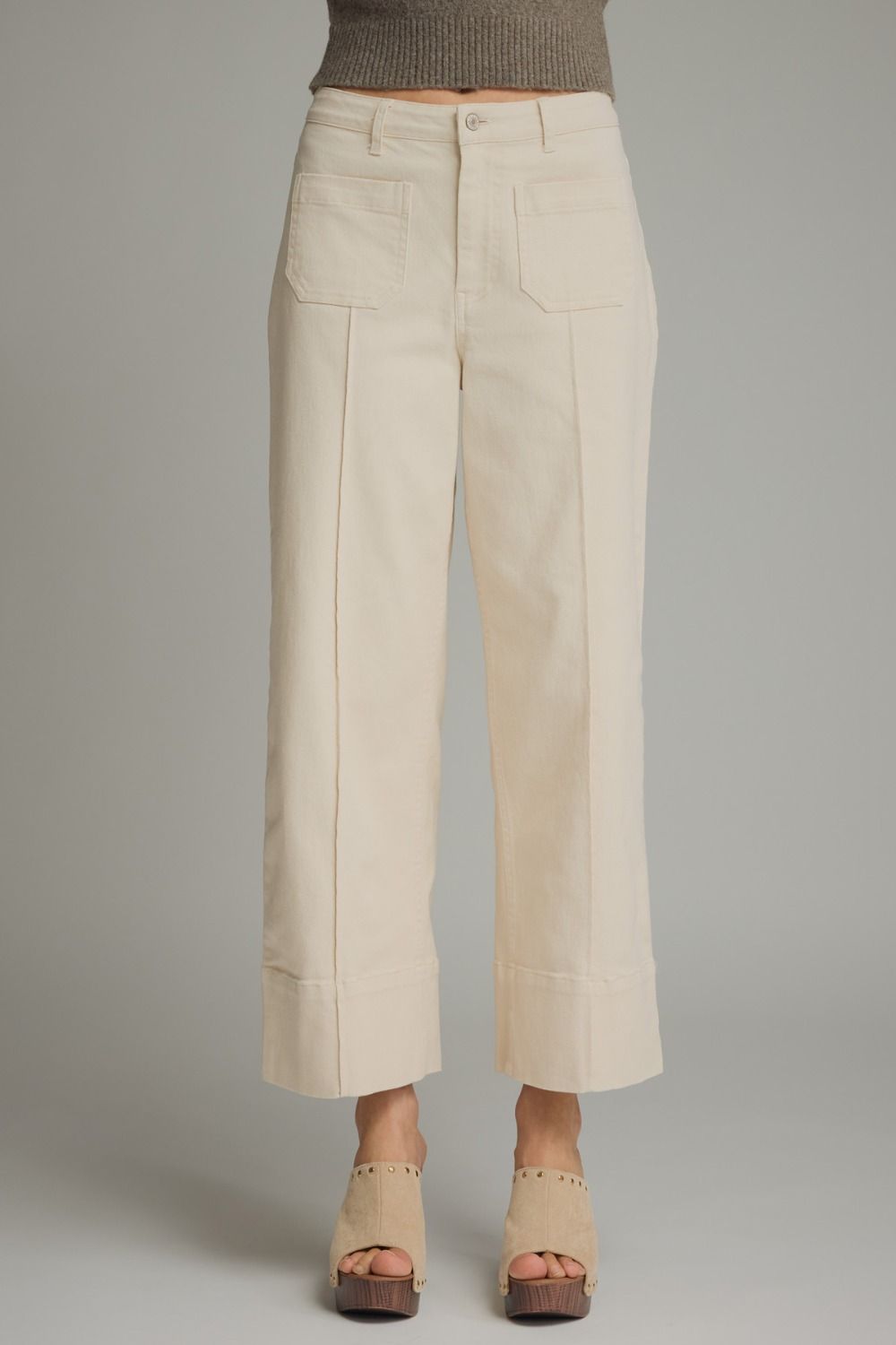 Beige pants worn by a person on a gray background