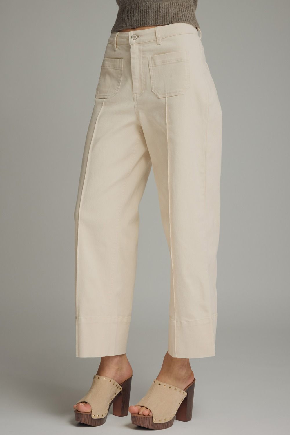 Beige pants worn by a person on a gray background