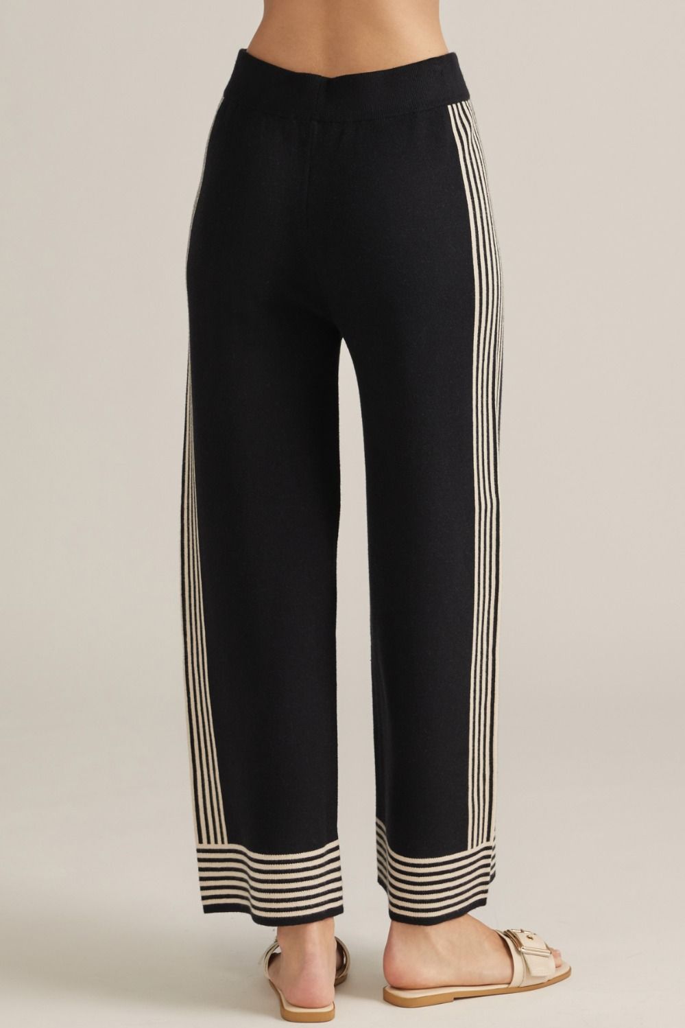 Black wide-leg pants with cream side stripes and striped cuff at the hem.