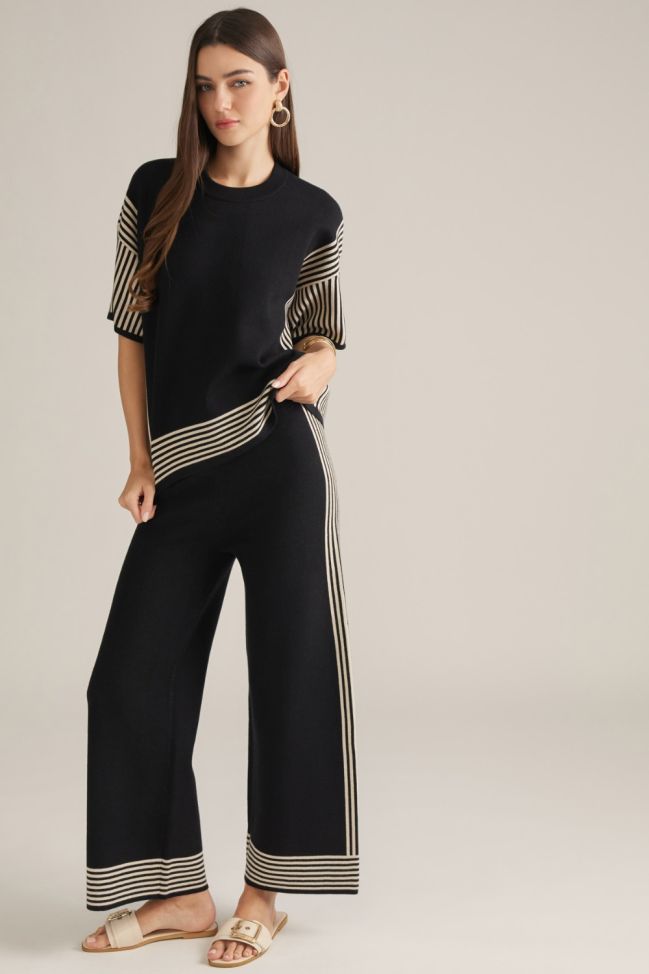 Black wide-leg pants with cream vertical stripes and striped hem border, elastic waist.