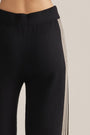Black wide-leg pants with cream vertical stripe down the side and elastic waistband.