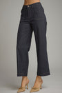 Dark wash cropped denim pants shown on a model from the waist down, paired with beige pointed-toe mule heels against a neutral gray studio background.