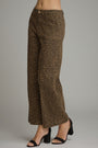 A person wearing leopard-print wide-leg cropped pants with black heeled sandals, shown from the waist down against a plain light gray studio background.