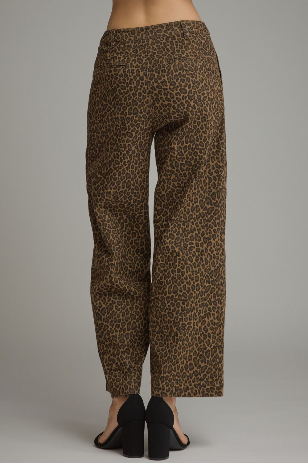 A pair of wide-leg cropped pants with a brown and black leopard print pattern, shown on a model from the back against a neutral gray background.
