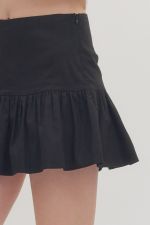 Black skirt worn by a person on a white background