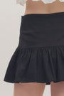 Black skirt worn by a person on a plain background