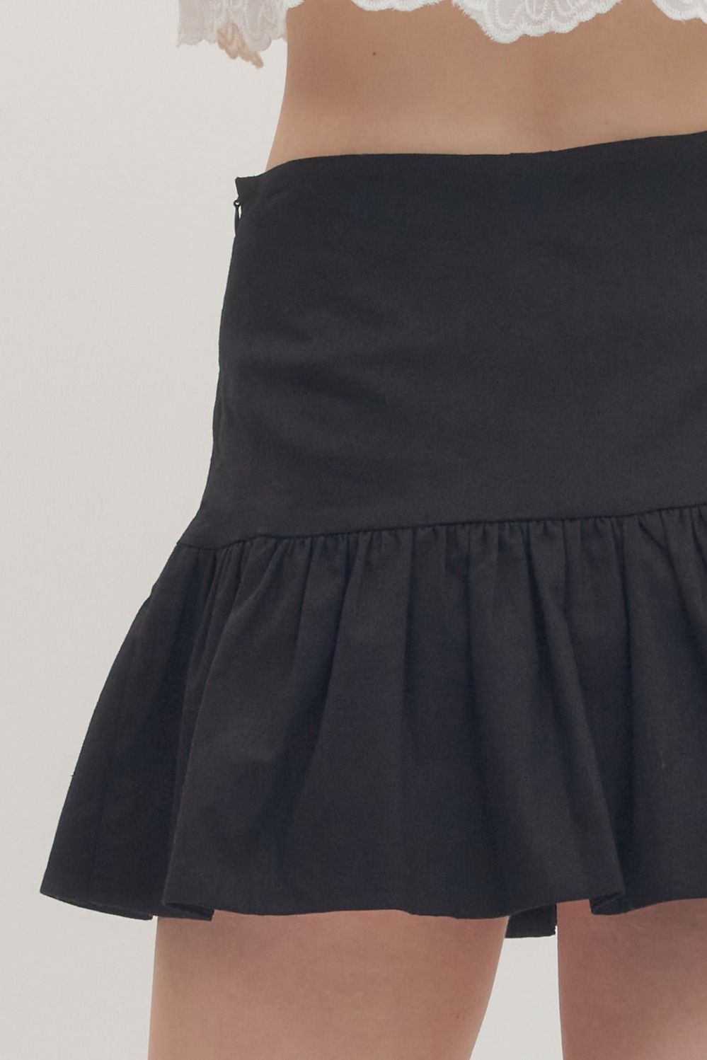Black skirt worn by a person on a plain background