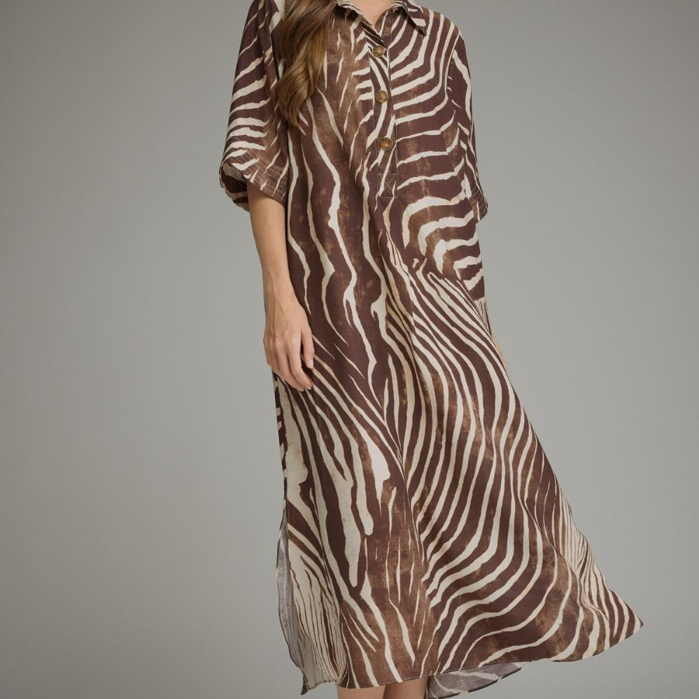 A woman modeling a brown and beige zebra-print midi shirt dress with three-quarter sleeves, paired with black flats, against a solid gray studio background.