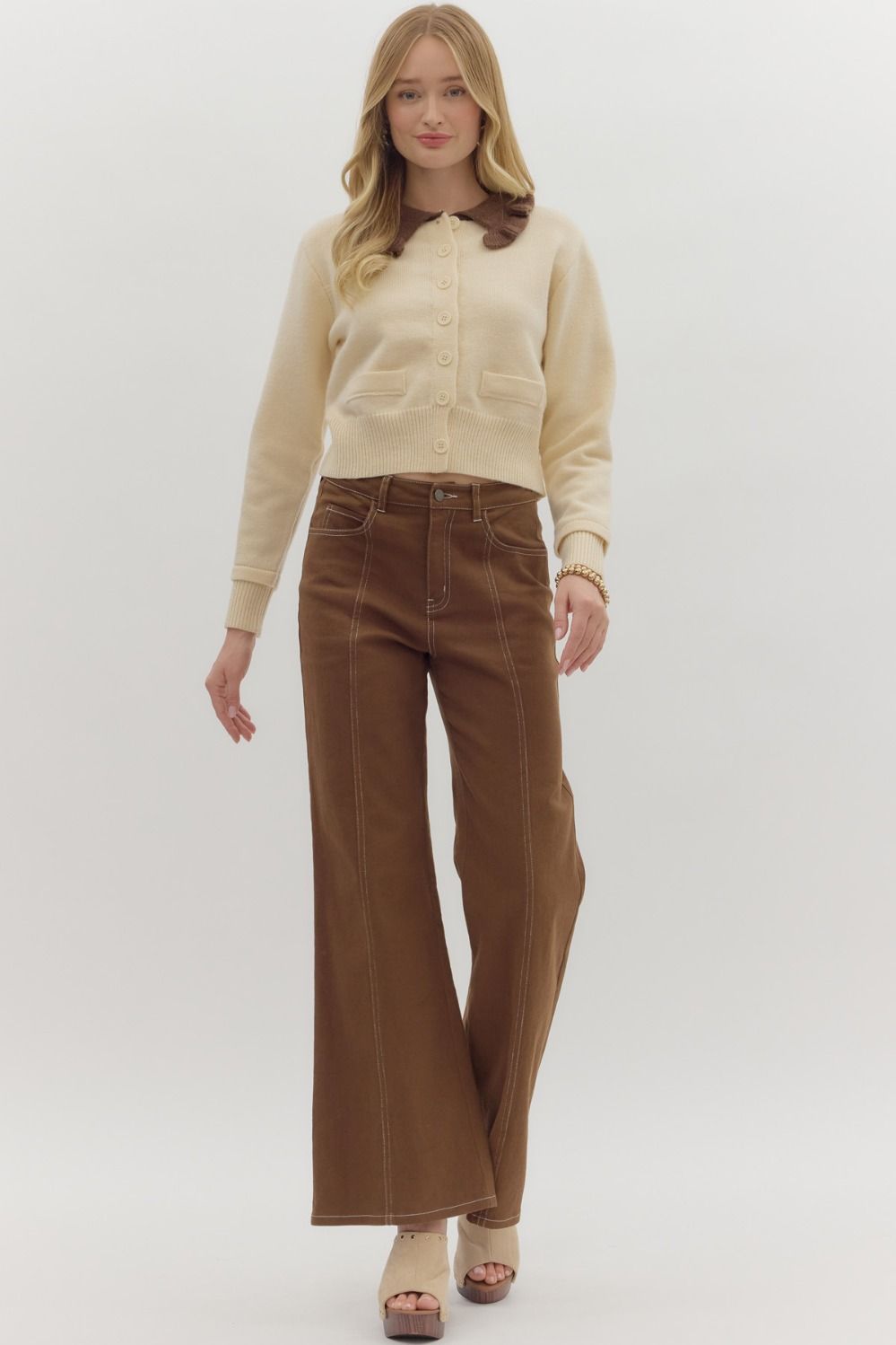 women wearing a long sleeve cropped sweater with a brown ruffle collar detail
