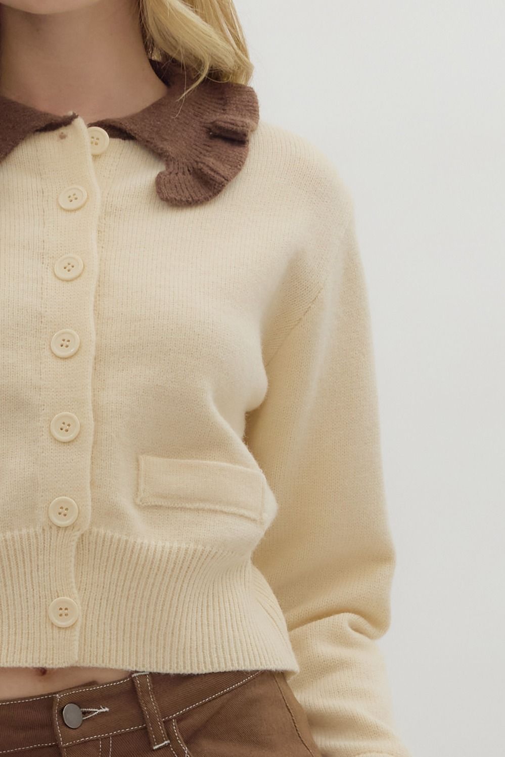 women wearing a long sleeve cropped sweater with a brown ruffle collar detail