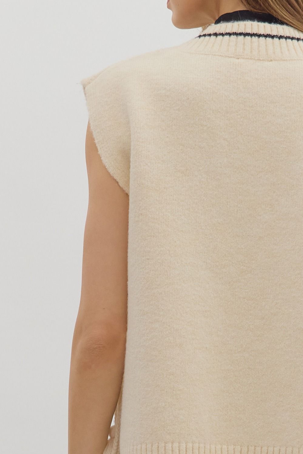 women wearing an oversize sleeveless sweater with thread detailing