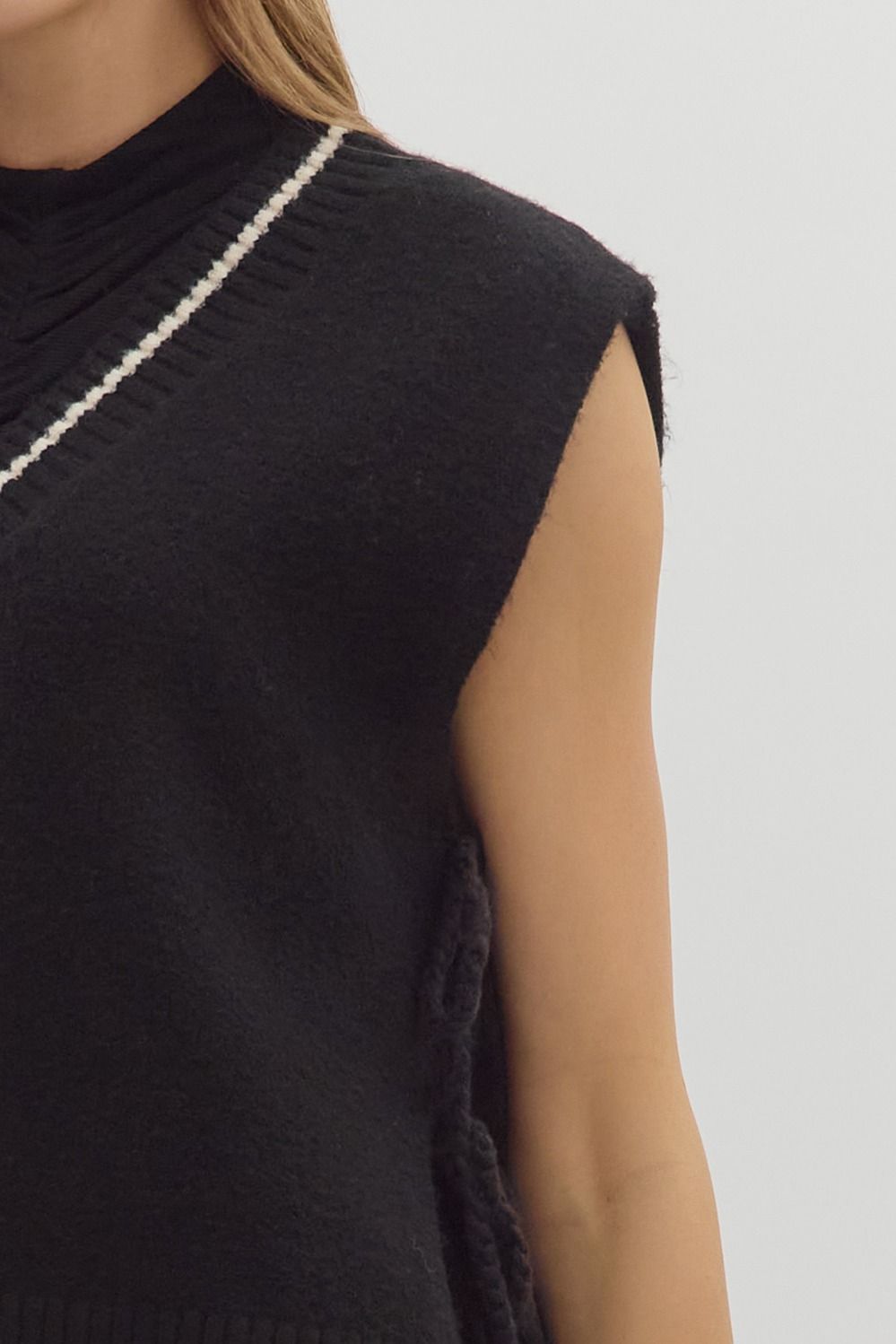 women wearing an oversize sleeveless sweater with thread detailing