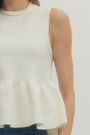 White sleeveless top worn by a person on a plain background
