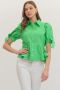 Woman wearing a green blouse with puff sleeves on a white background