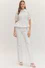 Woman wearing a white outfit on a plain background