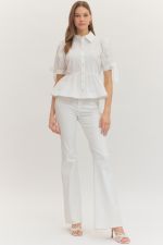 Woman wearing a white outfit on a plain background
