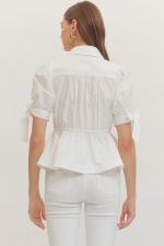 Person wearing a white blouse and pants against a plain background