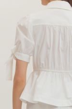 White blouse with rolled-up sleeves on a blurred background