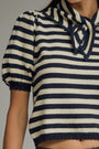 Navy and white striped sweater with a lace-up detail on a neutral background