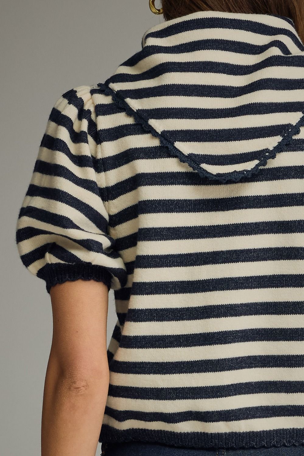 Navy and white striped sweater with a hood on a neutral background