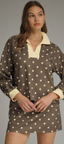 Woman wearing a polka dot dress with a plain background