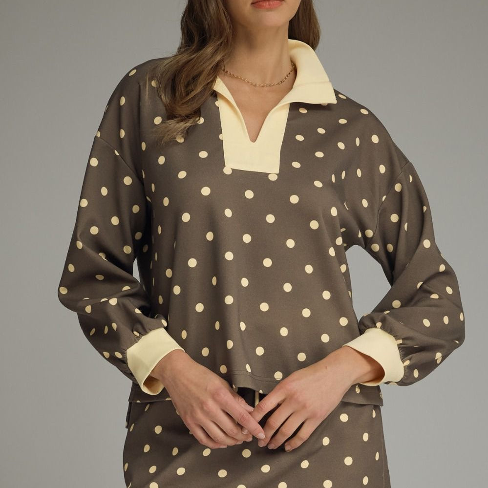 Woman wearing a polka dot dress with a plain background