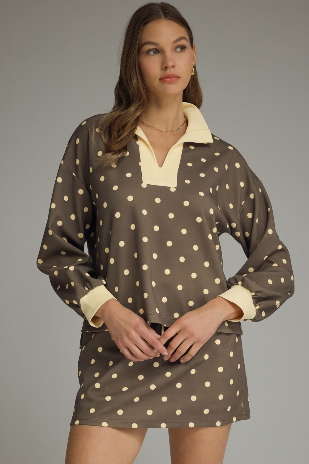 Woman wearing a polka dot dress with a plain background