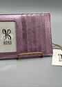 Pink leather cardholder with 'Hobo' branding on a gray background