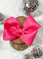 Large pink bow on a wooden block with disco balls around