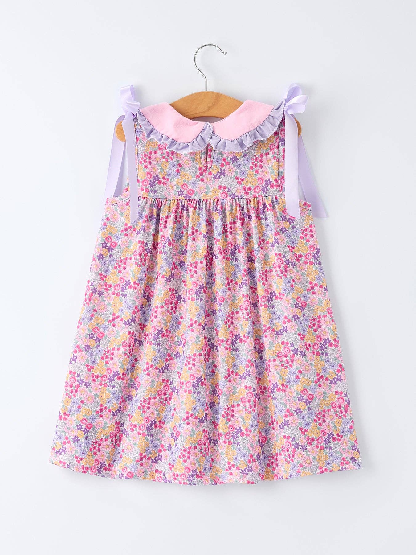 Floral dress on a hanger against a white background