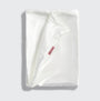 White satin pillowcase with a brand label on a light gray background