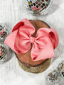 Pink bow on a wooden block with disco balls in the background