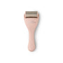 Pink derma roller with gold head on a white background