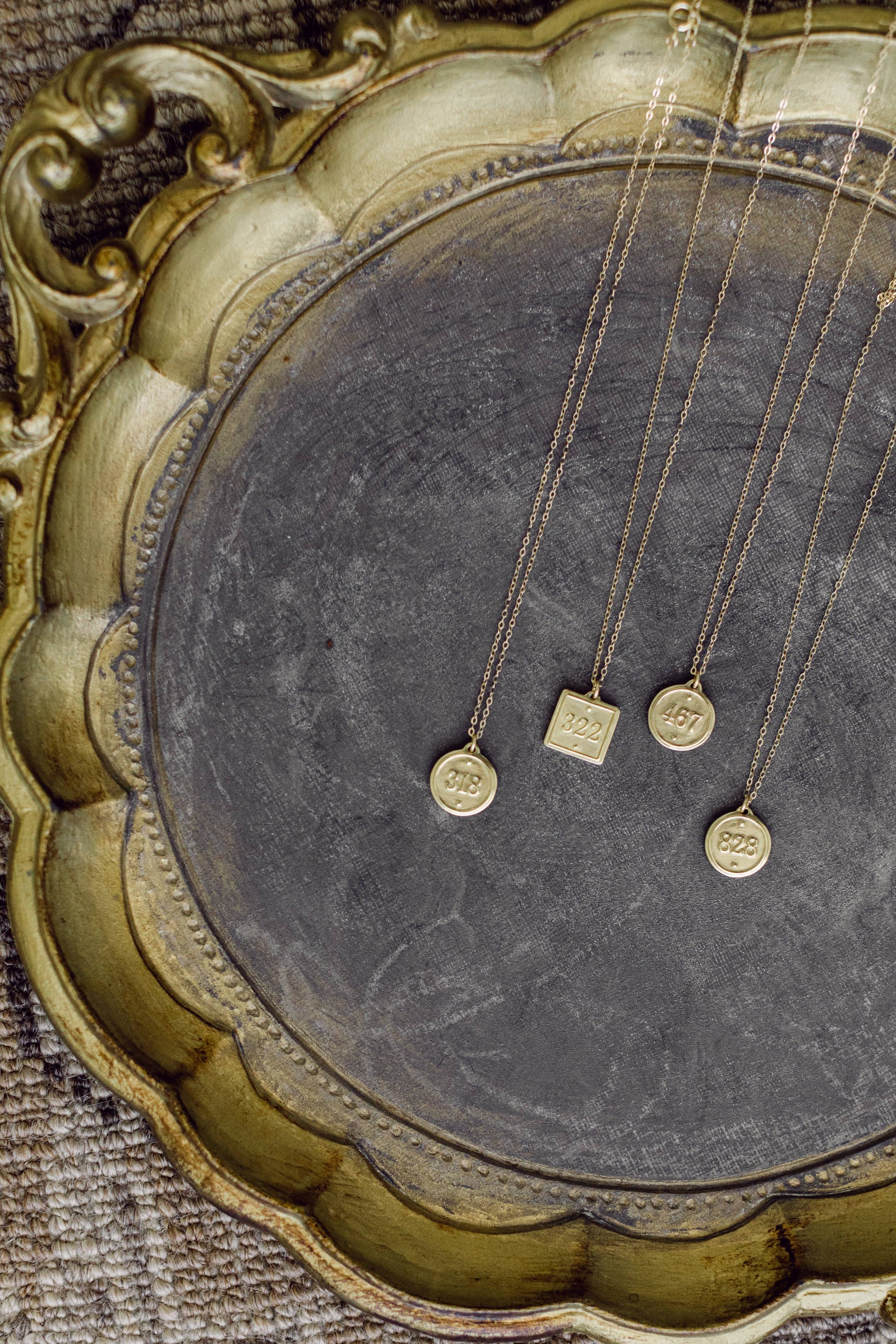 Gold necklaces with pendants on a textured surface